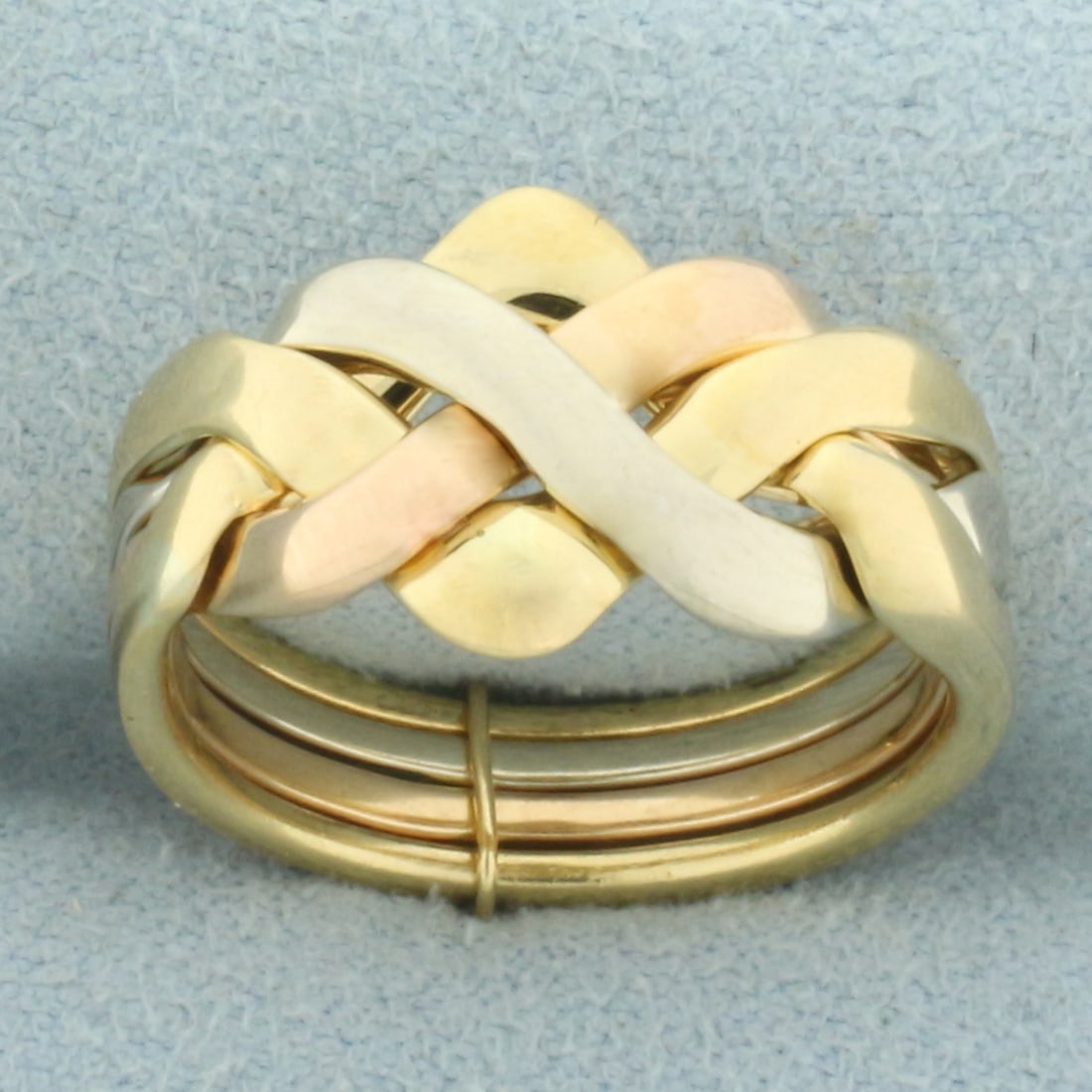 Italian Tri-Color Puzzle Ring in 18k Yellow, White, and Rose Gold: In 18k yellow, white, and rose gold. 4 rings fit together like a puzzle. 11.2mm wide at center. Size: 6.5. 8.3g.
