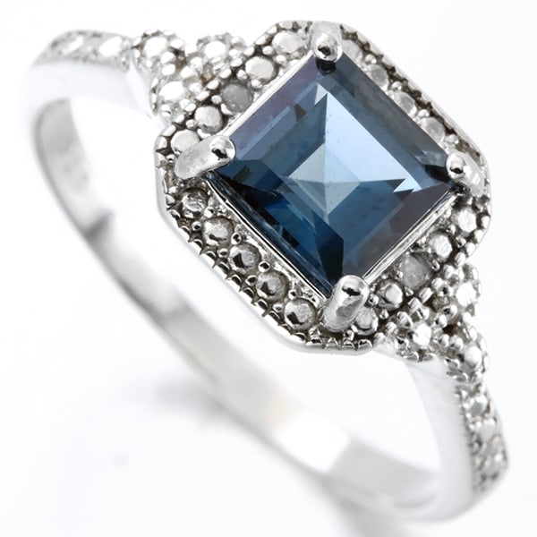 London Blue Topaz and Diamond Ring in Sterling Silver: In platinum over .925 sterling silver. Contains one 1.5ct London blue topaz gemstone, accented with two diamonds, .01ctw. Size 7. 2.7g