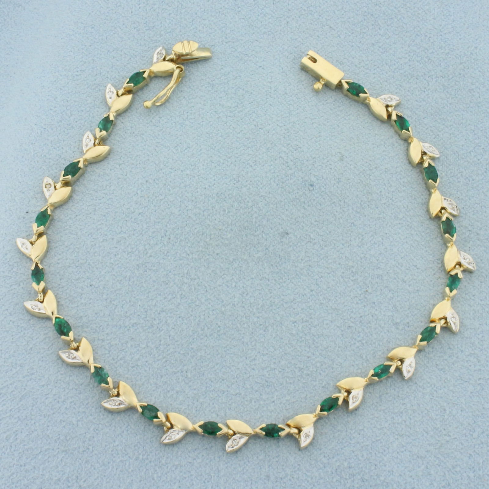 Emerald and Diamond Nature Leaf Tennis Bracelet in 14k Yellow Gold: In 14k Yellow Gold. Contains seventeen 4mm high quality natural Emerald gemstones with intense color. Also contains eighteen high quality 1/2pt diamonds. 7 inches long. Slide clasp with safety latch.