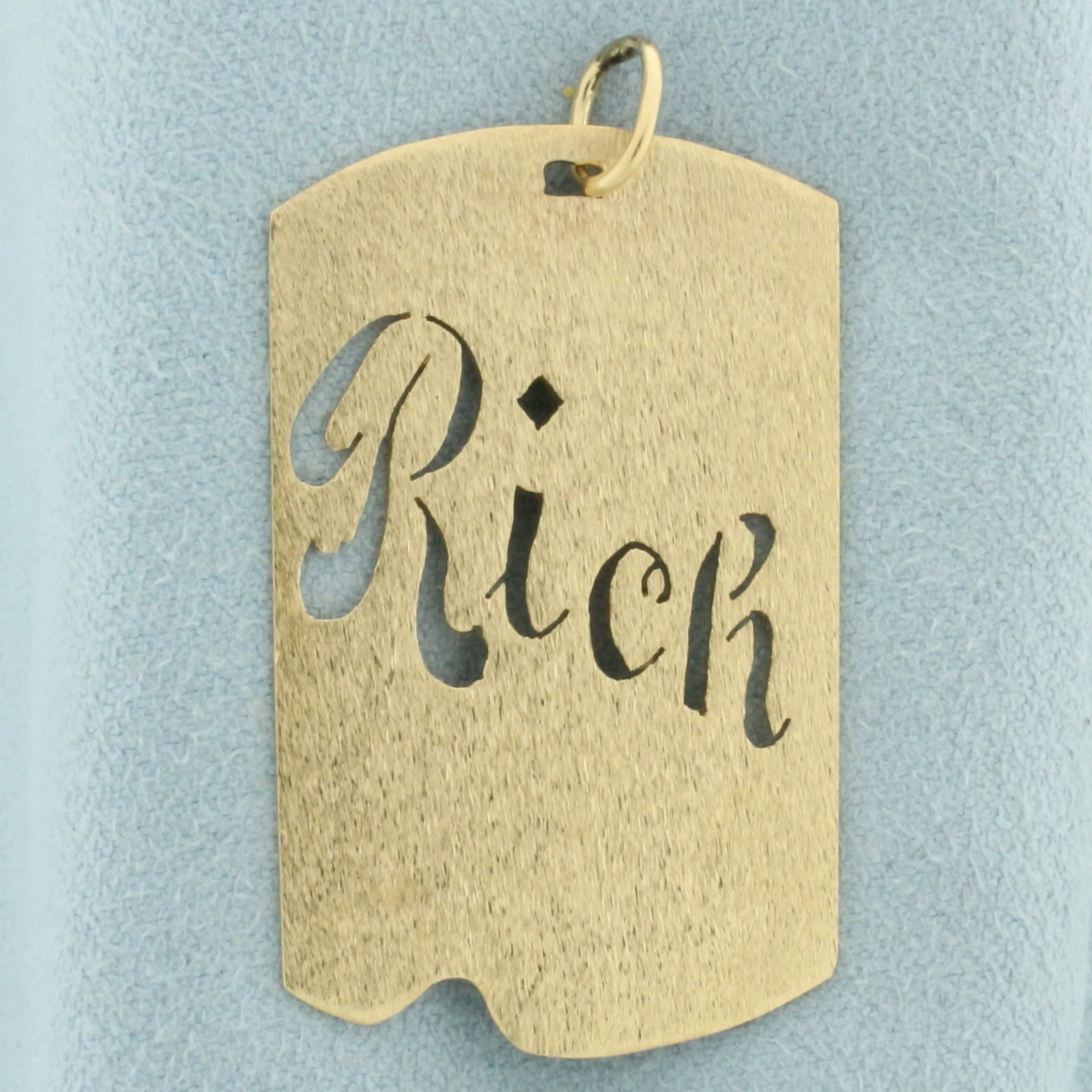 Name Rich Pendant in 14k Yellow Gold: In 14k yellow gold. 1 5/8 inches long and 7/8 inches wide. 5.9g.