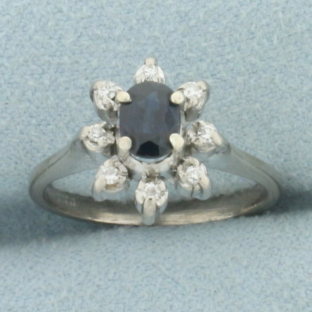 Sapphire and Diamond Flower Ring in _k Yellow Gold: In _k yellow gold. Contains one high quality natural 6mm Sapphire gemstone, approximately 1/2ct, with vibrant color and excellent clarity. Also contains eight high quality 1/2pt diamonds. 12mm wide at