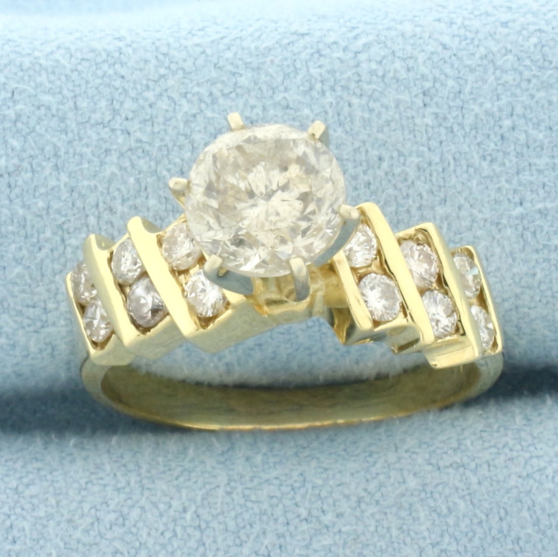 Diamond Engagement Ring in 14k Yellow Gold: In 14k Yellow Gold. Contains one 1.55ct round brilliant diamond, K color/I clarity. Also contains twelve diamonds in shank, 3/4ct TW, of similar high quality. Size 9.25. 6.0g.