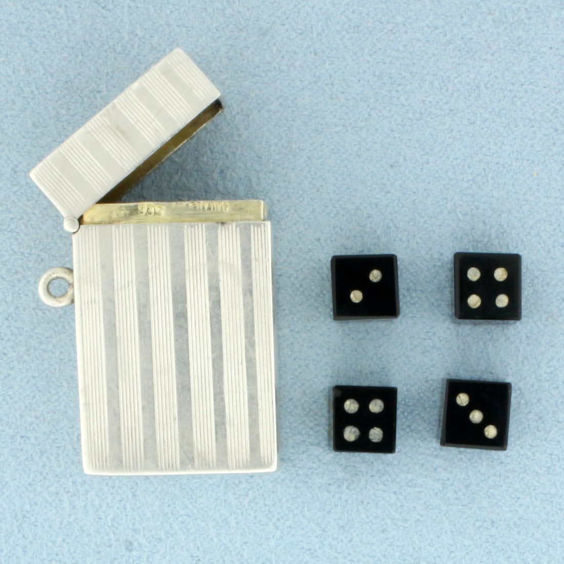 Antique German Miniature Dice Case Pendant or Charm in Sterling Silver: In .935 Sterling Silver. Contains four original dice. 1 1/8 inch long. 3/4 inch wide. Stamped "935 Sterling" and numbered "99" inside.