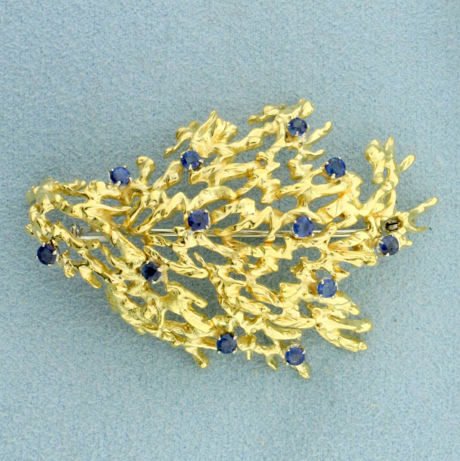 Italian Designer Sapphire Pin in 18K Yellow Gold: In 18K Yellow Gold. Contains twelve high quality natural 2.5mm AAA Sapphire gemstones with vibrant color and excellent clarity. 1 7/8 inches long. 1 1/4 inches wide. 11.4g