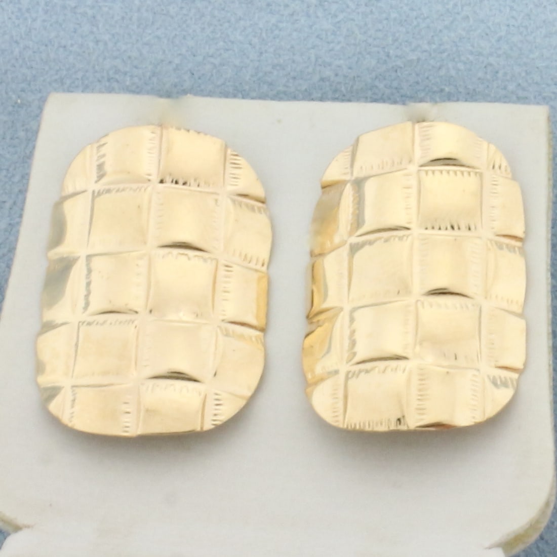 Quilted Design Button Earrings in 14k Yellow Gold: In 14k Yellow Gold. 1 inch long. 5/8 inch wide. Friction backs. 2.7g.