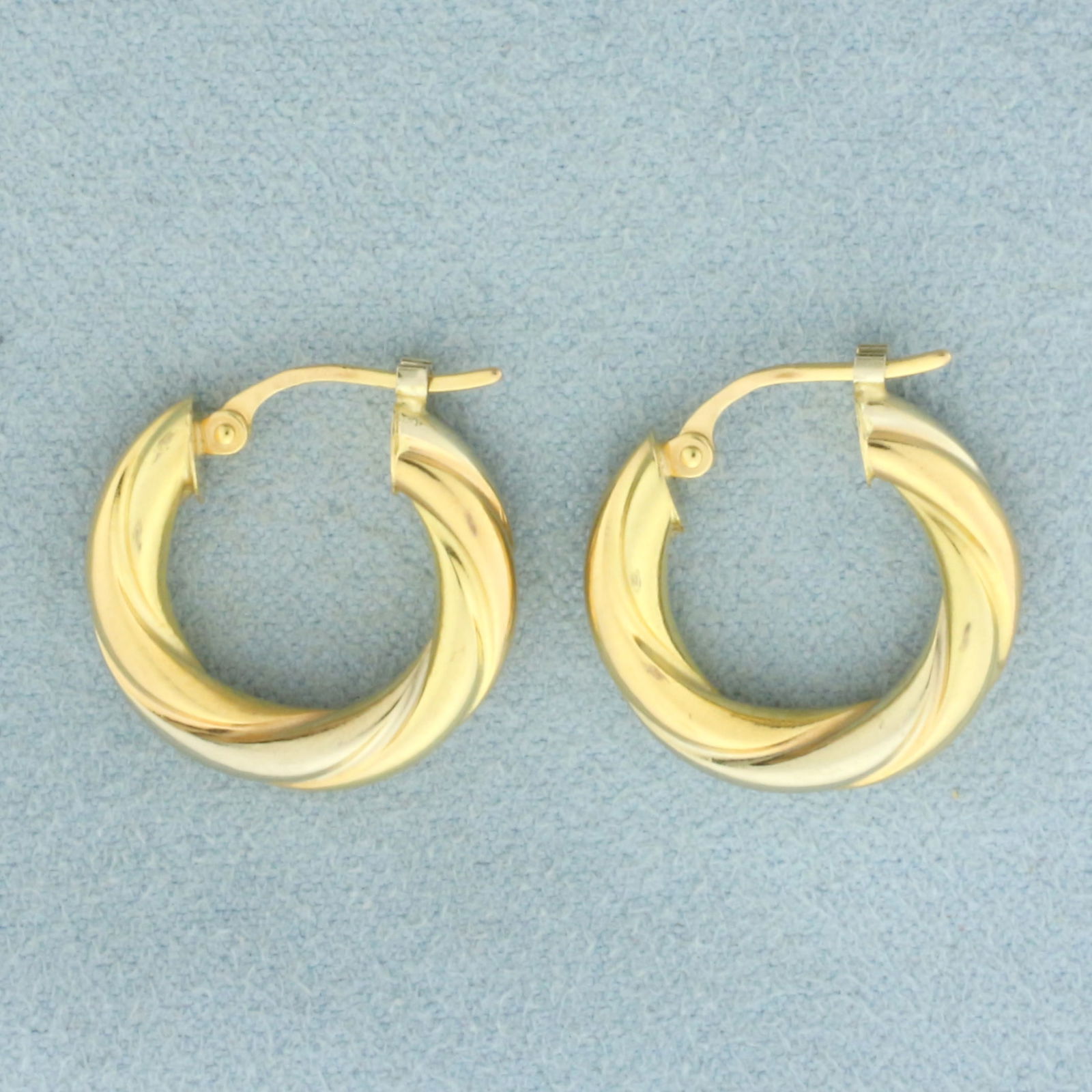 Two Tone Twisting Hoop Earrings in 18k Yellow and White Gold: In 18k Yellow and White Gold. 5/8 inch long. 3.4mm thick. Leverback. 1.7g.