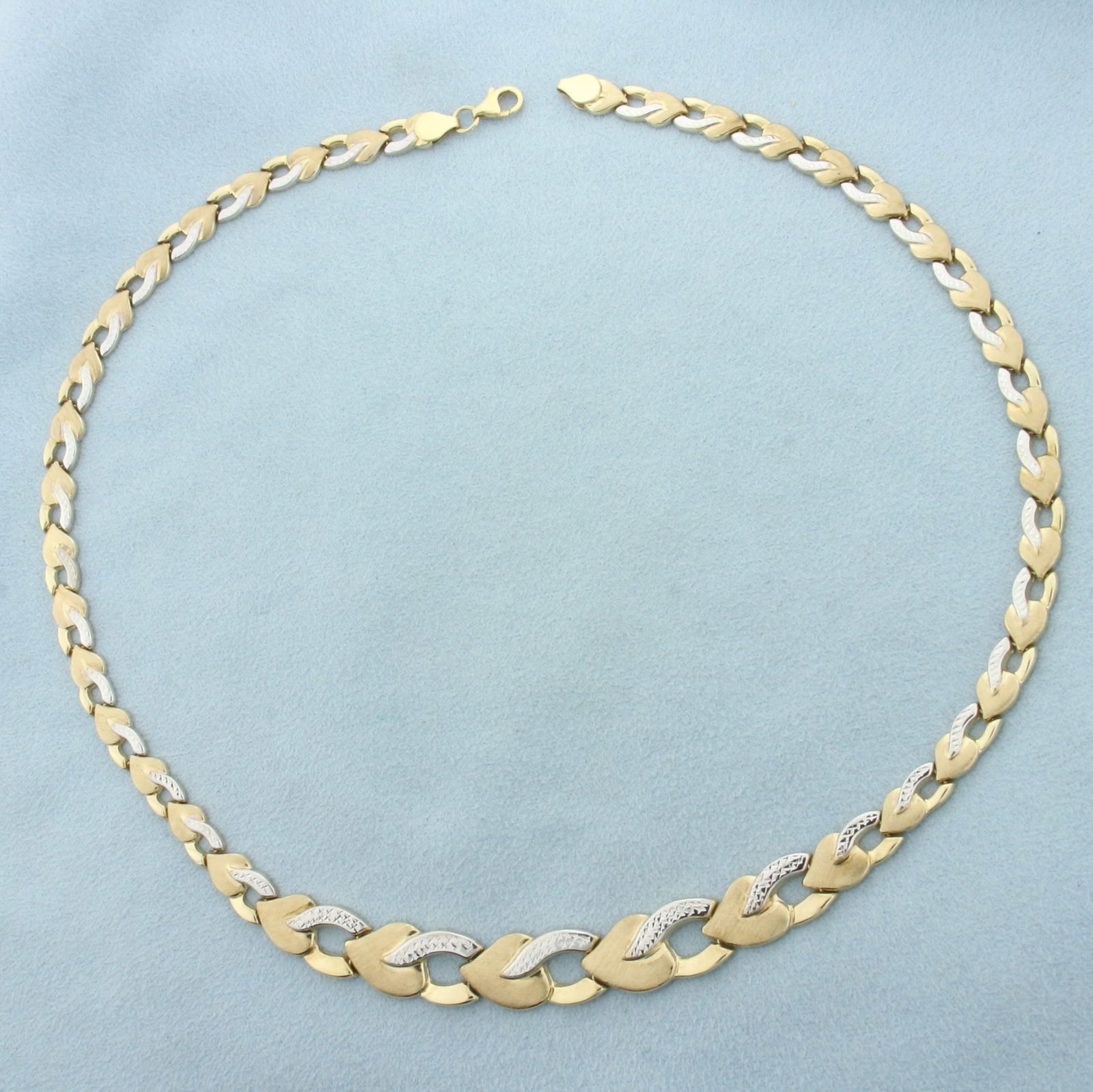 Heart Link Necklace in 10k Yellow and White Gold: In 10k Yellow and White Gold. 17 1/2 inches long. 10.7mm wide at widest point. Matte and high polish finish, diamond cut, for unique look. Lobster clasp. 11.1g.