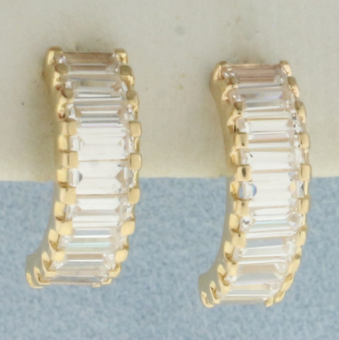 Baguette CZ Half Hoop Earrings in 14k Yellow Gold: In 14k Yellow Gold. Contains twenty high quality 4.5mm baguette CZ gemstone with excellent cut and clarity. 5/8 inch long. Friction backs. 2.4g.