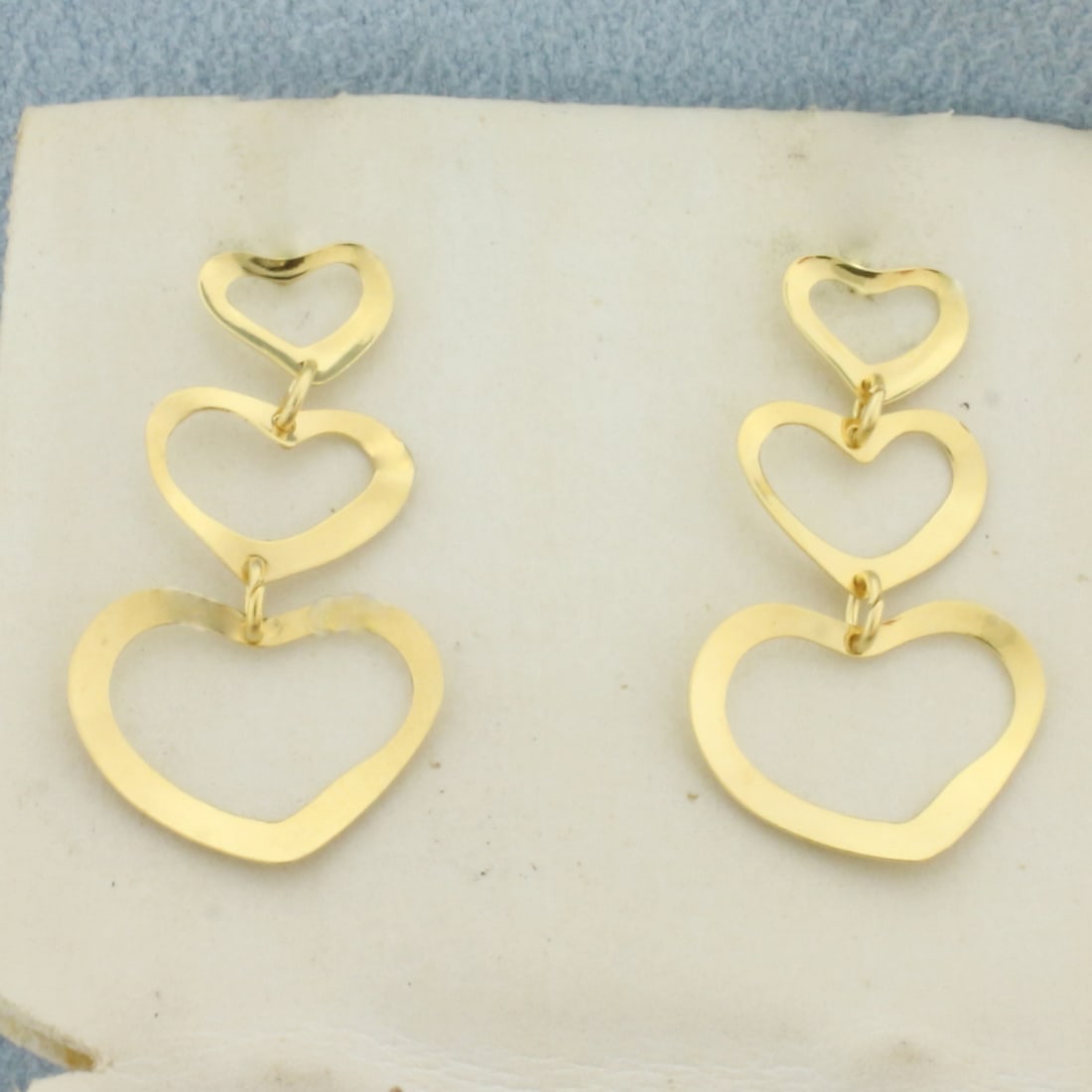 Heart Dangle Earrings in 14k Yellow Gold: In 14k Yellow Gold. 7/8 inch long. 1/2 inch wide. Friction backs. .8g.