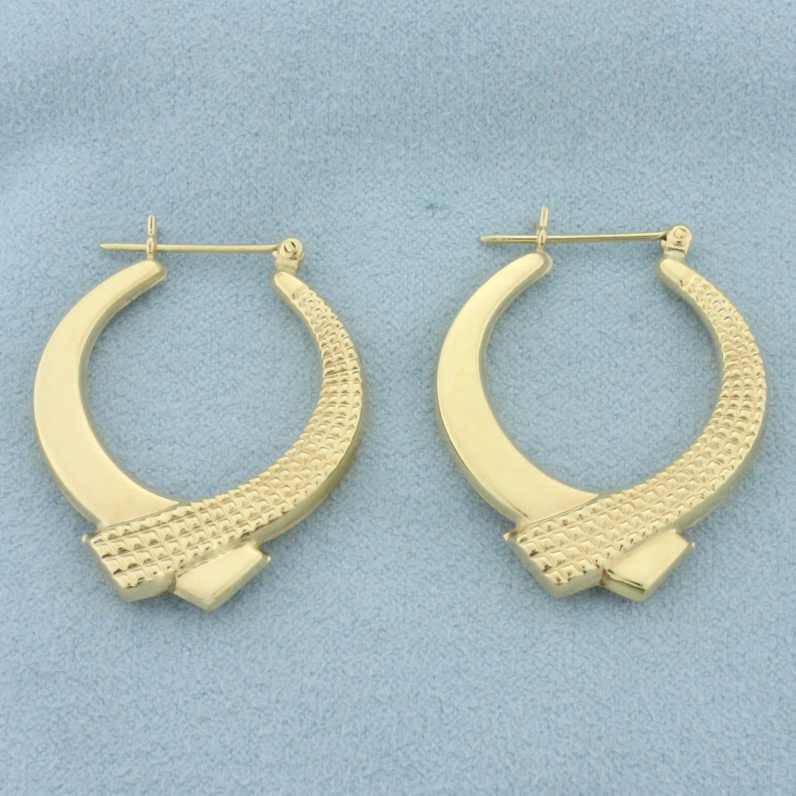 Crossover Ribbon Design Hoop Earrings in 14k Yellow Gold: In 14k yellow gold. 1 1/4 inches long and 1 inch wide. 4.1g.