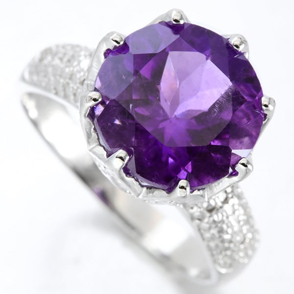 Claw Set Amethyst and Diamond Ring in Sterling Silver: In platinum over .925 sterling silver. Contains one large 4.3ct amethyst gemstone, claw set in a vintage style mounting with two genuine diamonds, .01ctw. Size 7. 5.2g