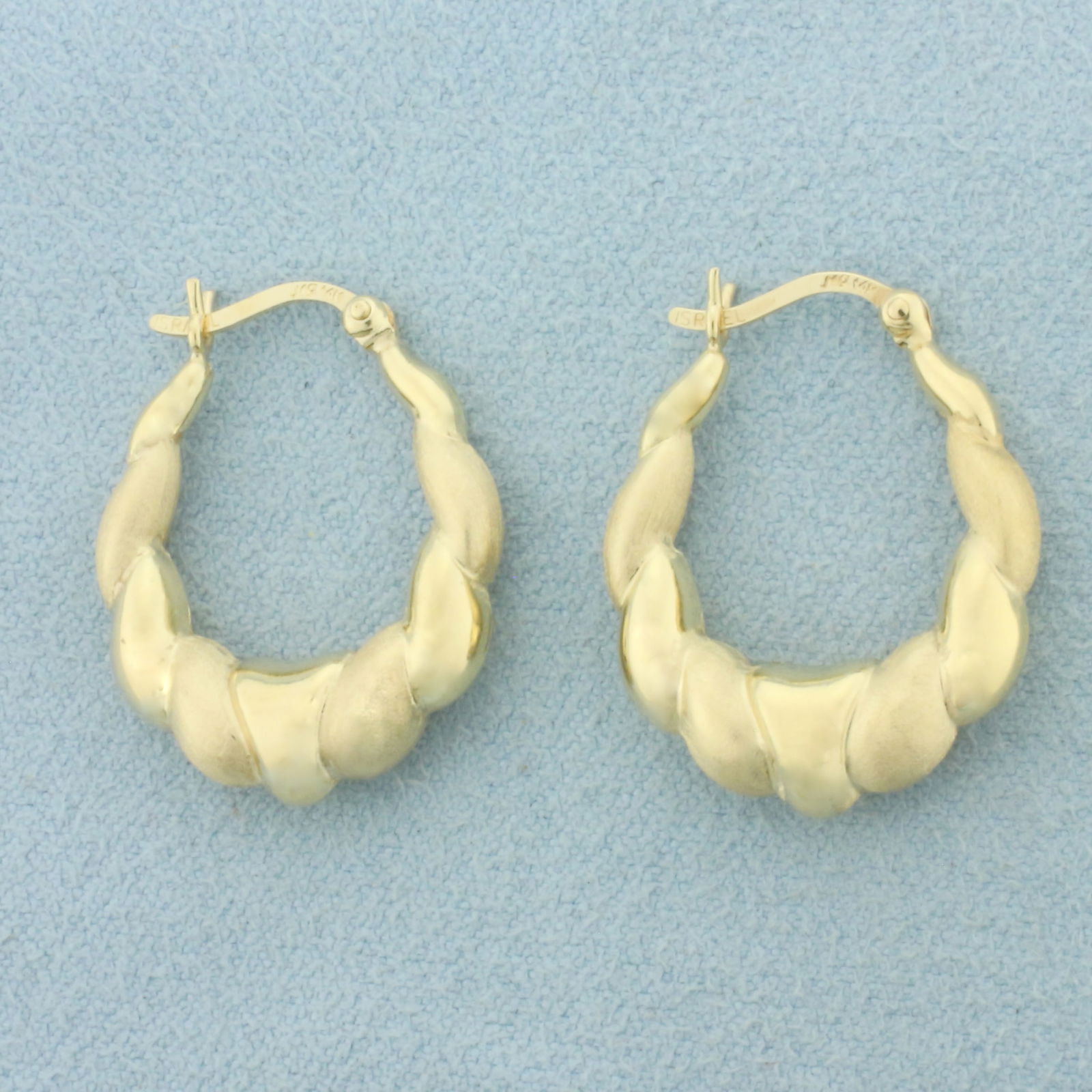 Satin and High Polish Finish Puffy Hoop Earrings in 14k Yellow Gold: In 14k Yellow Gold. 7/8 inch long. 3/4 inch wide. Leverbacks. 2.5g.