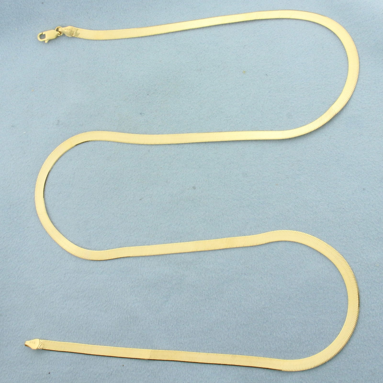 24 Inch Reversible Herringbone Link Chain Necklace in 14k Yellow Gold: In 14k Yellow Gold. 24 inches long. 4mm wide. Traditional herringbone link on one side, diamond cut "X" reflected design on other. Made in Italy. Lobster clasp. 9.4g.