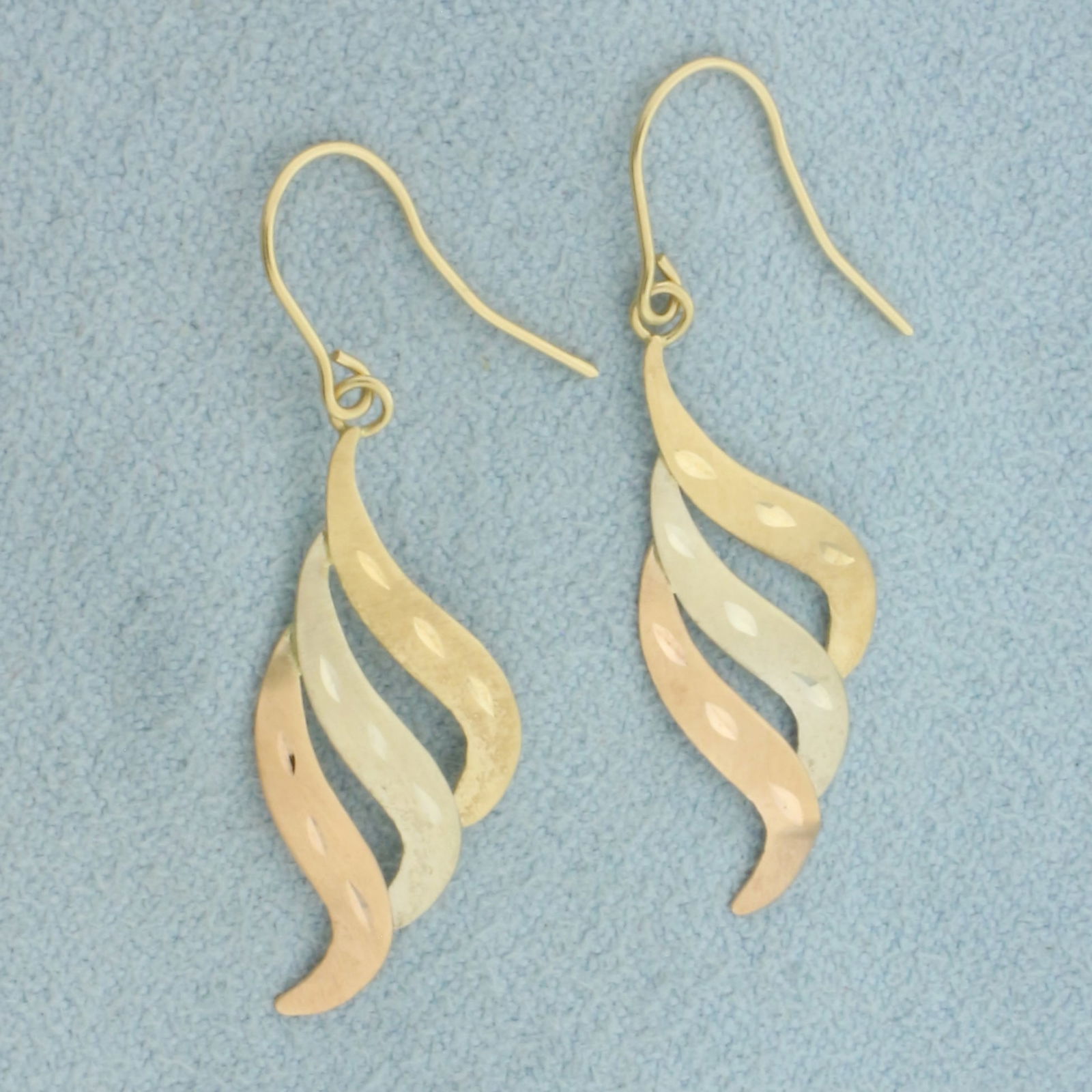 Tri-Color Dangle Earrings in 14k Yellow, White, and Rose Gold: In 14k Yellow, White, and Rose Gold. 1 inch long. 3/8 inch wide (at widest). Matte finish and diamond cut for unique look. Wire hook. 0.6g.