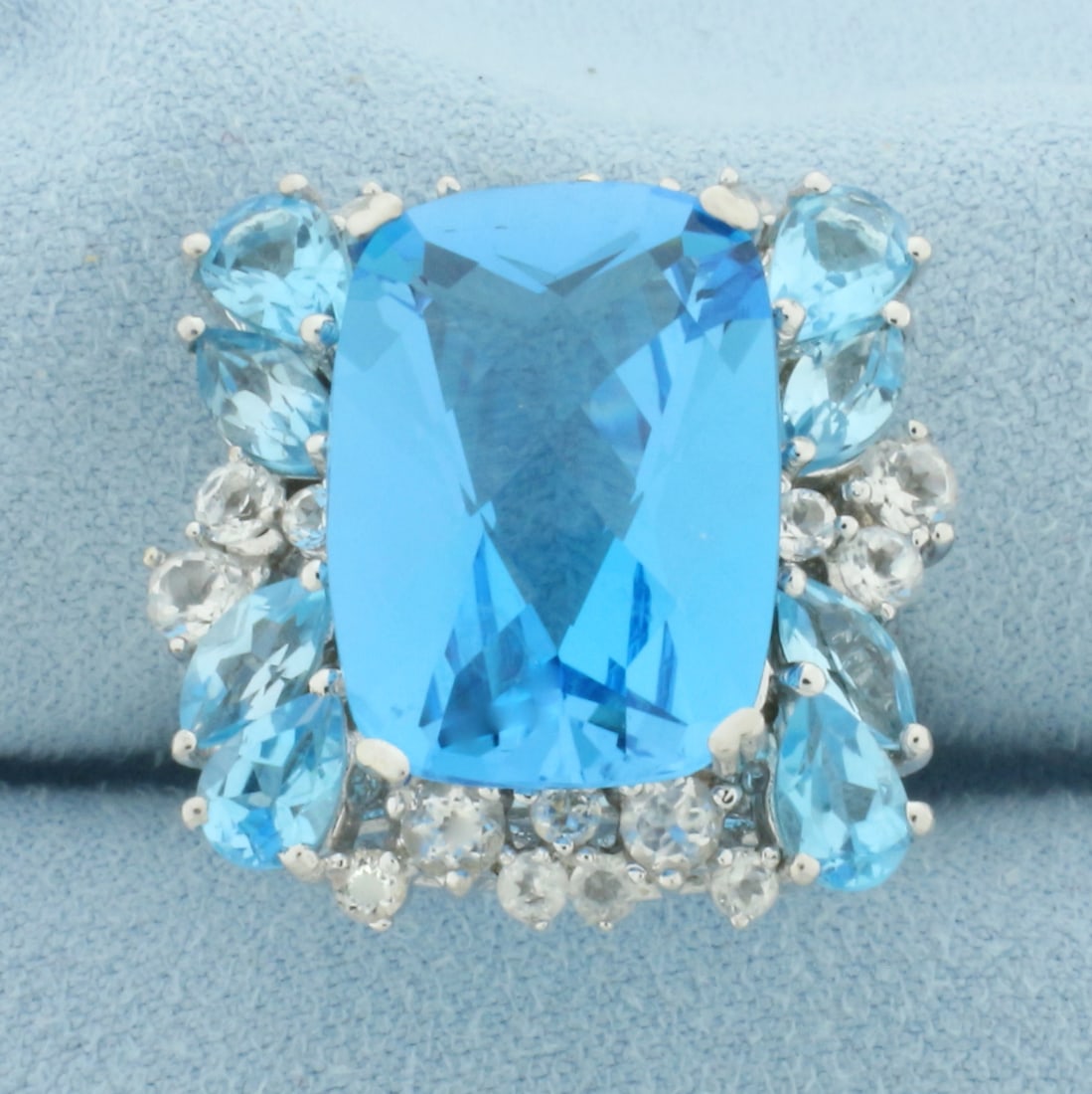 Swiss Blue Topaz Statement Ring in 10k White Gold: In 10k White Gold. Contains one 18x13mm cushion, four 4x6mm pear, and four 6x3mm marquise cut high quality natural Swiss Blue Topaz gemstones with electric blue color and excellent clarity. Also conta