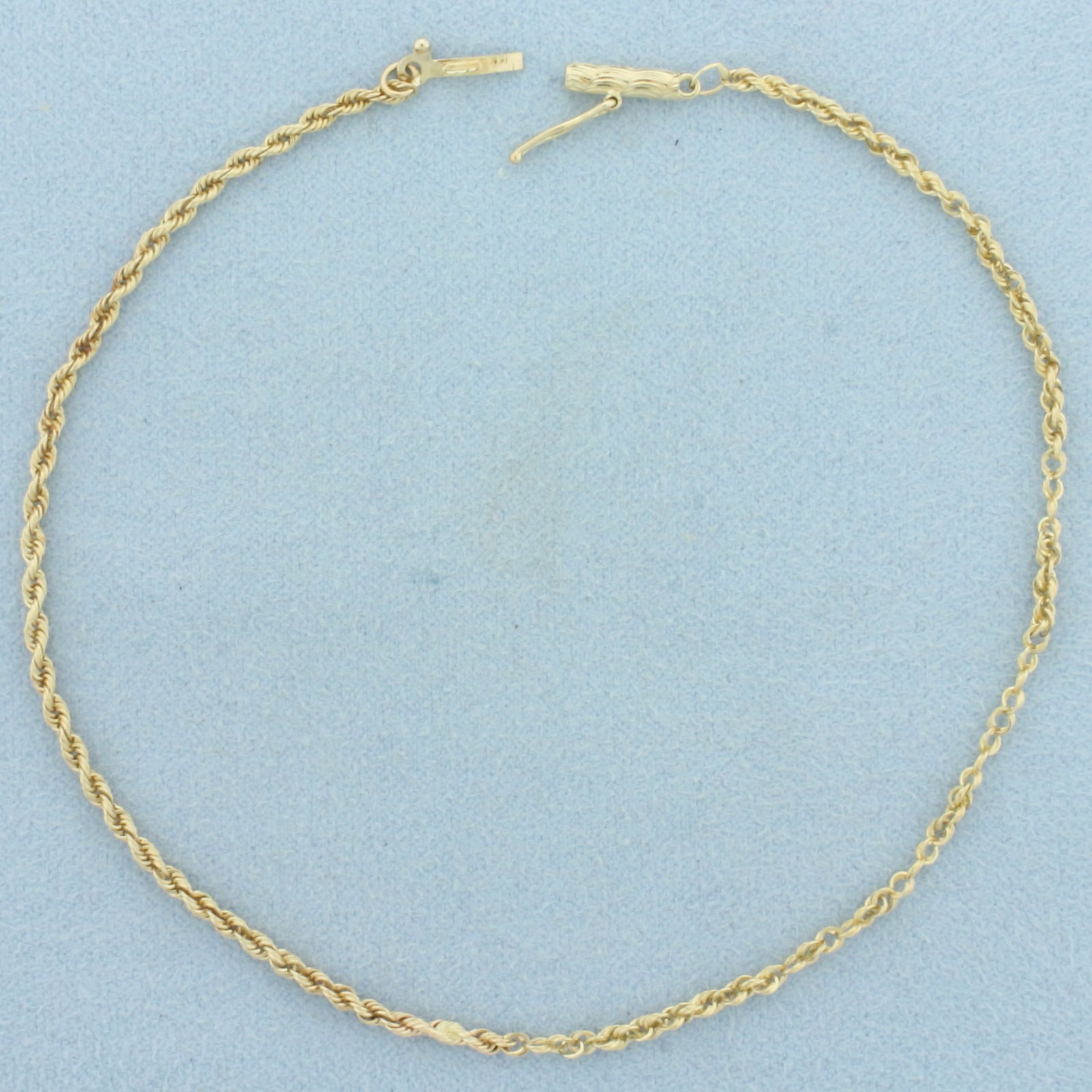 Rope Link Anklet in 14k Yellow Gold: In 14k Yellow Gold. 9 1/4 inches long. 1.8mm wide. Some repairs as shown, not noticeable. Barrel clasp with safety latch. 2.6g