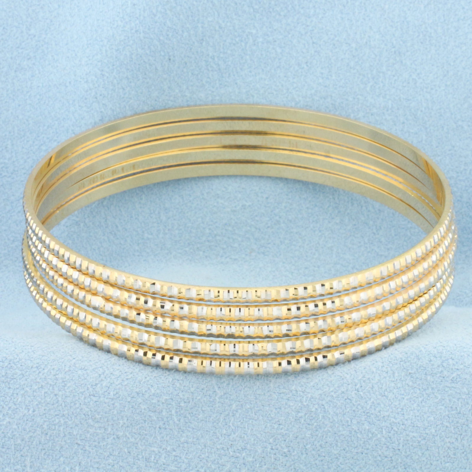 Two Tone Stacking Bangle Bracelets Set of 5 in 18k Yellow & White Gold: 18k yellow and white gold. Set of 5 bracelets with unique 2-tone beveled vertically striped design. Interior diameter: 2 1/4". Each bracelet is 2mm wide. 27.5g.
