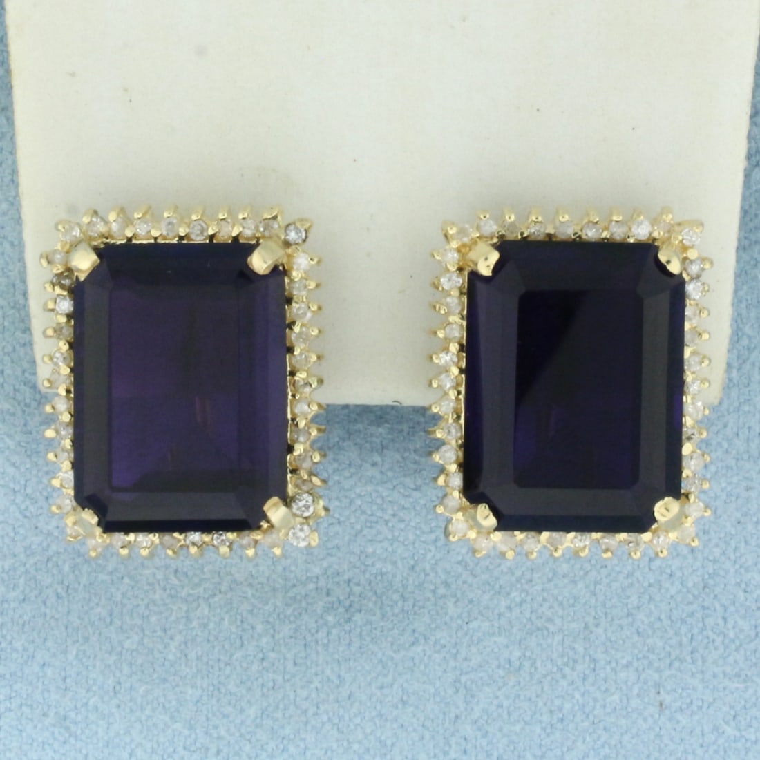 Large Amethyst and Diamond Halo Earrings in 14k Yellow Gold: In 14k Yellow Gold. Contains two high quality natural 16mmx12mm emerald cut Amethyst gemstones, approximately 20ct TW, with intense color and excellent clarity. Also contains eighty-four .01ct diamond