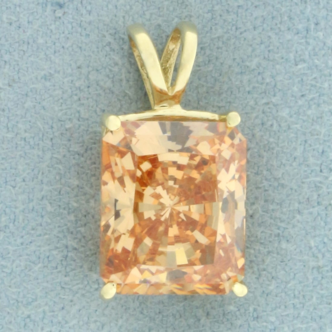 Orange Tourmaline Pendant in 14k Yellow Gold: In 14k Yellow Gold. Contains one 12x10mm high quality radiant cut natural Orange Sapphire gemstone, approximately 6.5cts, with vibrant color and excellent clarity. 3/4 inch long. 3/8 inch wide. 3.9g.