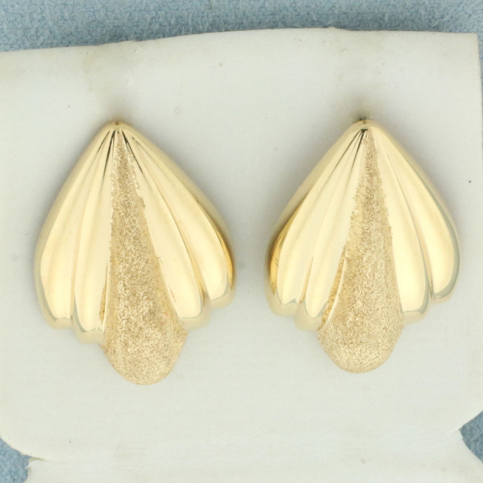 Sandblast Finish Fan Design Earrings in 14k Yellow Gold: In 14k yellow gold. Sandblast and high polish finish. 1 inch long and 5/8 inches wide. Friction backs. 2.6g.