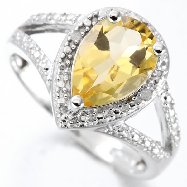 Pear Cut Citrine and Diamond Halo Ring in Sterling Silver: In platinum over .925 sterling silver. Contains one pear cut citrine gemstone, 1.55cts, accented with two diamonds, .01ctw. Size 6. 3.1g