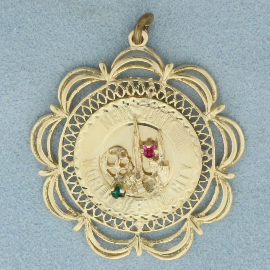 New York World's Fair City Pendant or Charm in 14k Yellow Gold: In 14k Yellow Gold. Contains high quality 2mm Emerald and Ruby gemstones with vibrant color. 1 3/8 inch long. 1 1/4 inch wide. 4.7g.