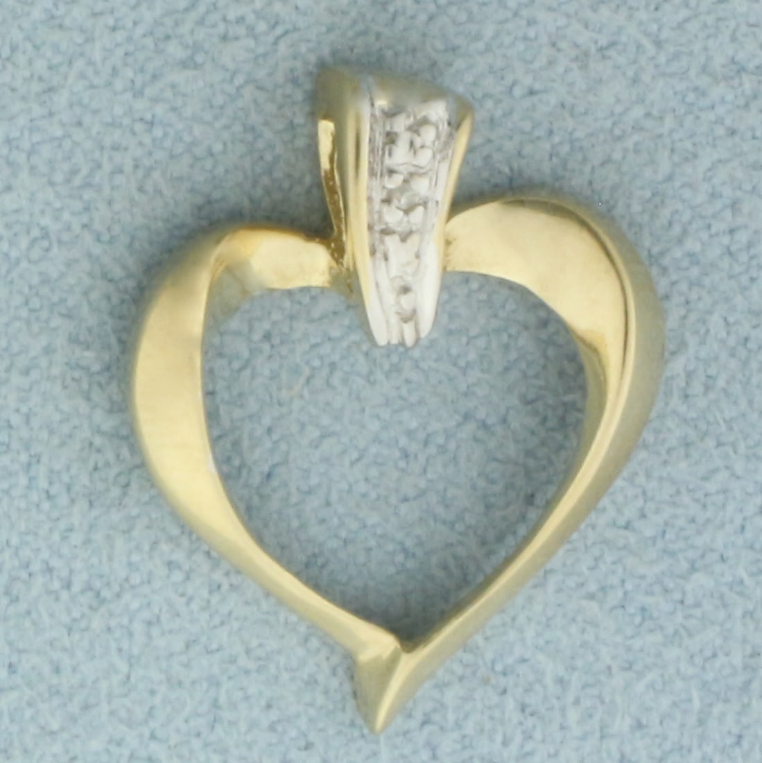 Diamond Heart Pendant in 10k Yellow Gold: In 10k Yellow Gold. Contains one 1/2pt high quality diamond. 7/8 inch long. 5/8 inch wide. 1.4g.