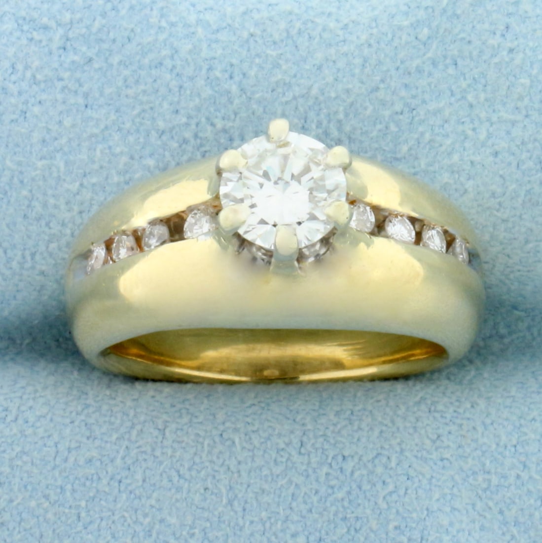 Vintage Channel Set Diamond Engagement Ring in 14K Yellow Gold: In 14K Yellow Gold. Center diamond is a high quality .9ct round brilliant diamond, VS clarity/G color, great cut for added brilliance. Also contains eight high quality .02ct Diamonds of similar high q