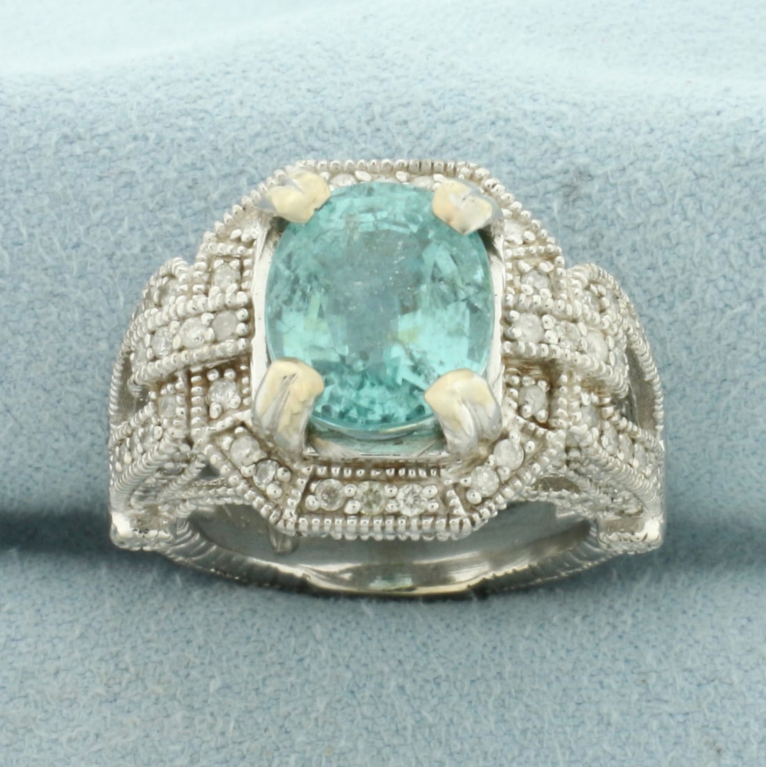 Paraiba Tourmaline and Diamond Ring in 14k Yellow Gold: In 14k Yellow Gold. Contains one 11x9.1mm high quality oval cut natural Paraiba Tourmaline gemstone, approximately 4cts, with intense color. Also contains 136 high quality diamonds, 1.5ct TW. Size 6.7