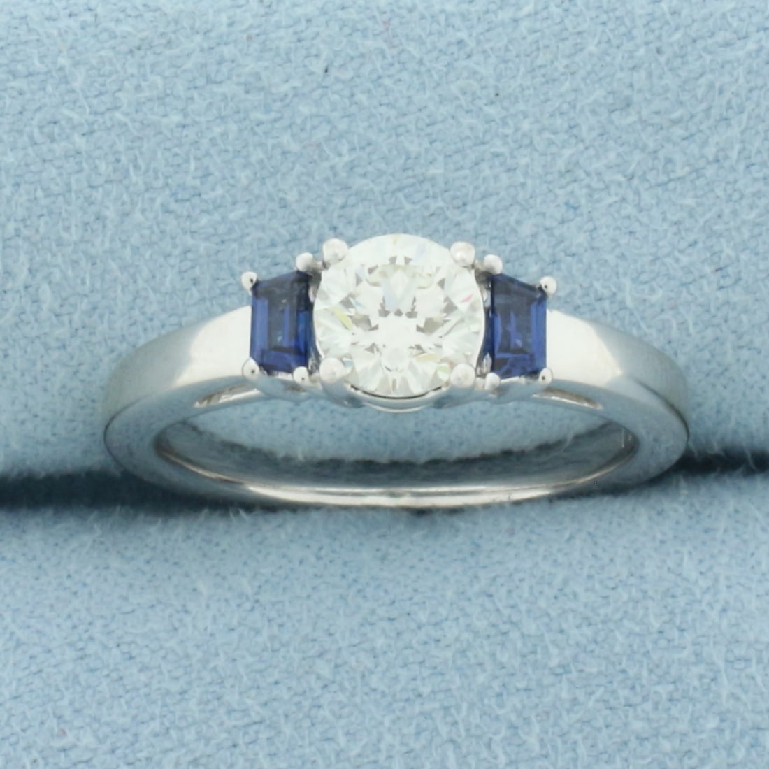 Diamond and Sapphire Three Stone Ring in 14k White Gold: In 14k White Gold. Contains one 3/4ct high quality diamond, VS clarity/H color, great cut for added brilliance. Also contains two 4x2mm trapezoid cut natural Sapphire gemstones, approximately .70ct TW