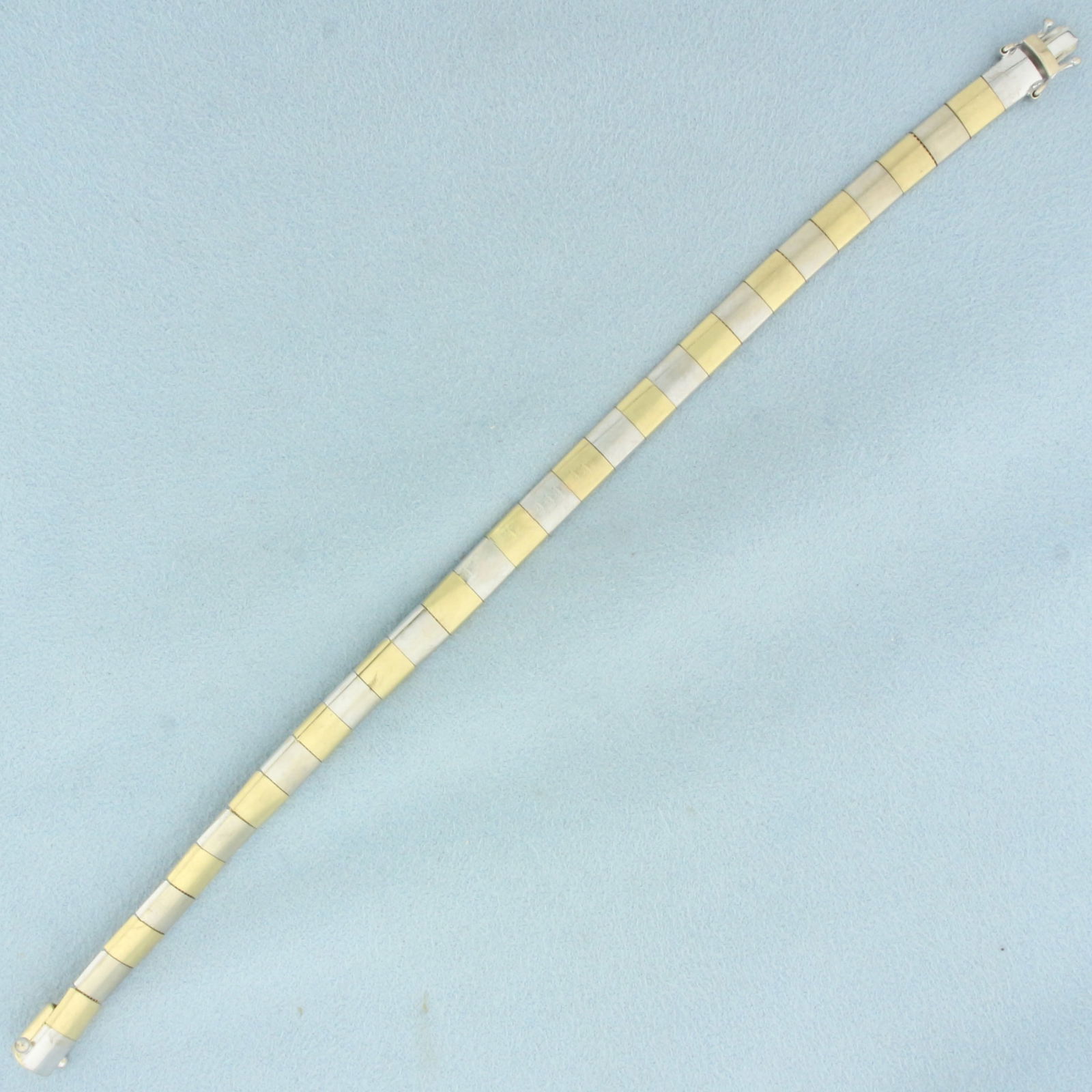 Square Link Checker Design Bracelet in 18k White and Yellow Gold: In 18k white and yellow gold. 7.5 inches long. 6mm wide. Slide closure with Double safety clasp. 20.4g.