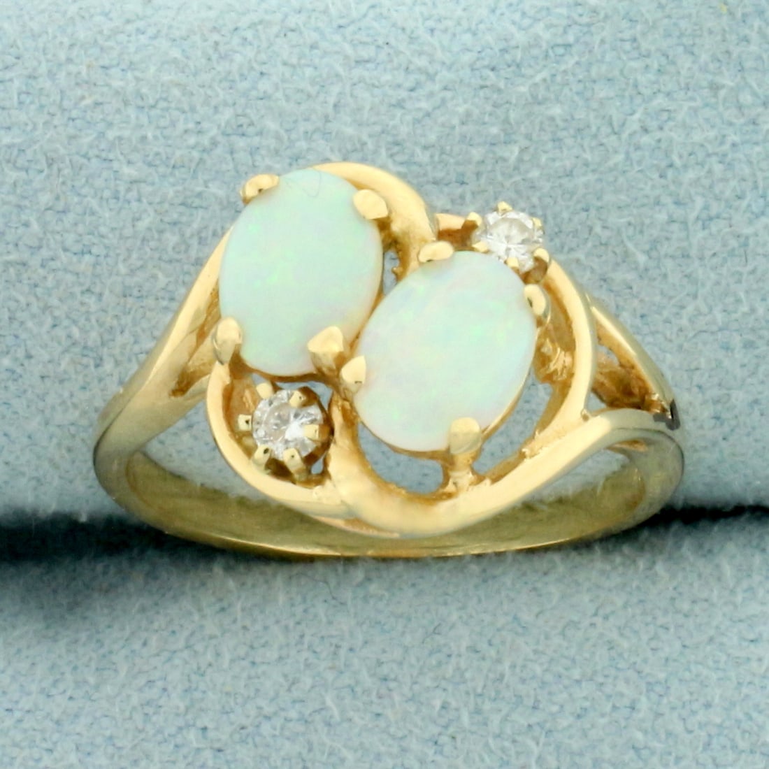 Double Opal and Diamond Ring in 14k Yellow Gold: In 14k yellow gold. Contains two high quality 7mm by 5mm Opal gemstones with excellent play of color with flashes of green, blue, orange, and red. Also contains two high quality .06ct diamonds, H colo