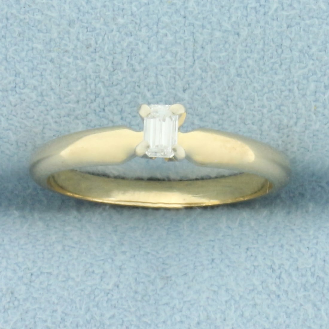 Emerald Shaped Diamond Solitaire Engagement Ring in 14k Yellow Gold: In 14k yellow gold. Contains one high quality 1/8ct emerald cut diamond, VS clarity/H color. Size: 5. 1.9g.