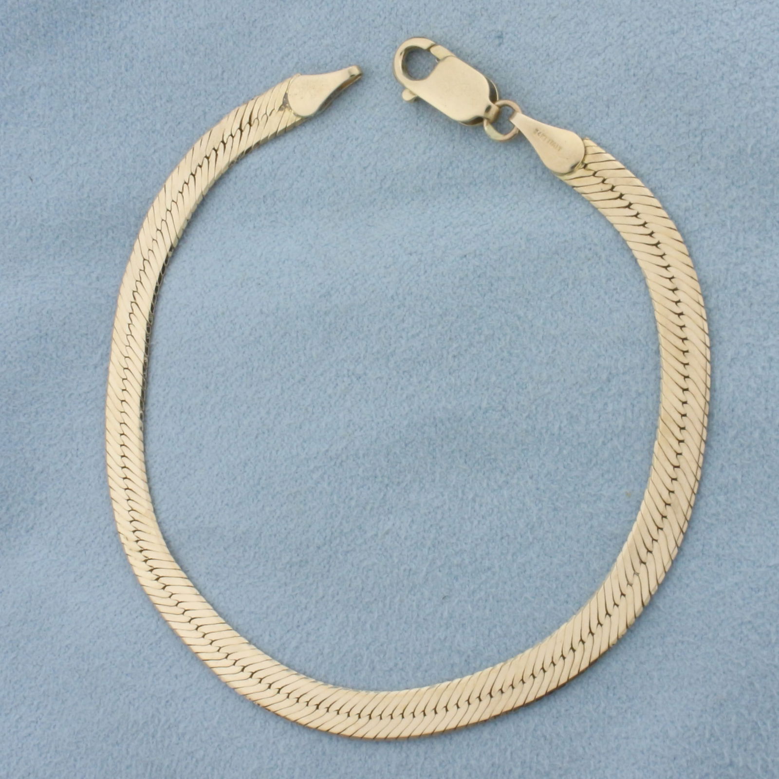 Italian Herringbone Bracelet in 14k Yellow Gold: In 14k Yellow Gold. 7 3/4 inch long. 4.5mm wide. Italian made. Large lobster clasp. 5.3g.