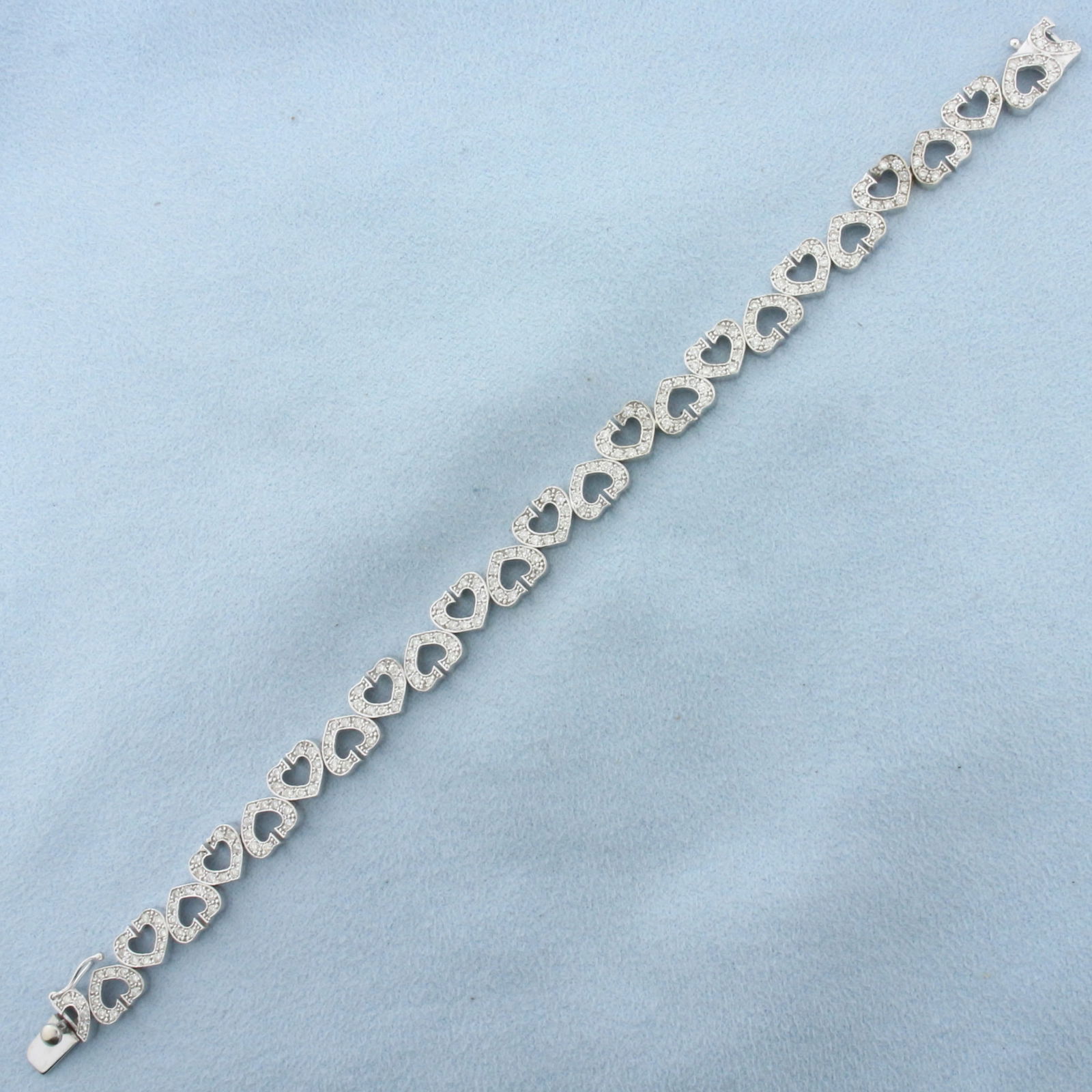 Diamond Heart Link Bracelet in 14k White Gold: In 14k White Gold. Contains two hundred and fifteen high quality diamonds, 1ct TW, SI clarity/H color. 7 1/4 inches long. 1/4 inch wide. Concealed slide clasp with safety latch. 14.4g.