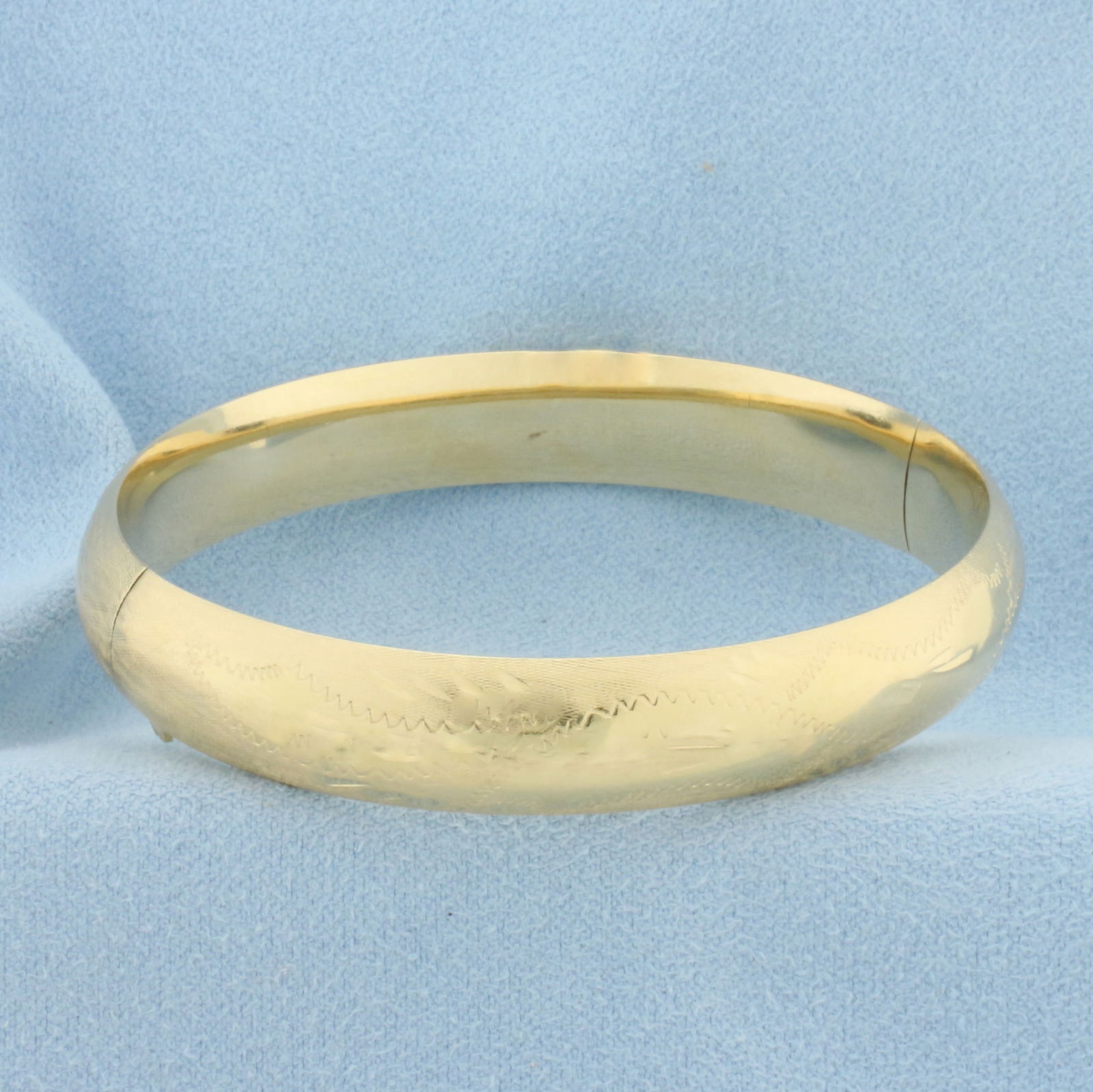 Etched Design Hinged Bangle Bracelet in 14k Yellow Gold: In 14k Yellow Gold. Interior dimensions: 2 1/4 inch by 2 1/8 inch. 10.5mm wide. Hinged closure. 14.2g.