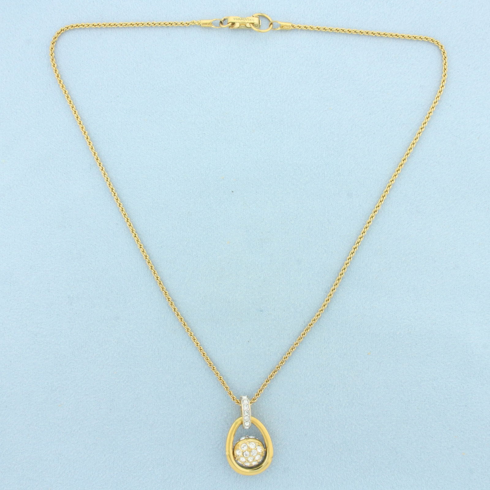 Swarovski Crystal Motion Ball Necklace: Gold Plated. 1 inch long by 5/8 inch wide pendant. 16 inches long chain. Ball spins. 10.5g.