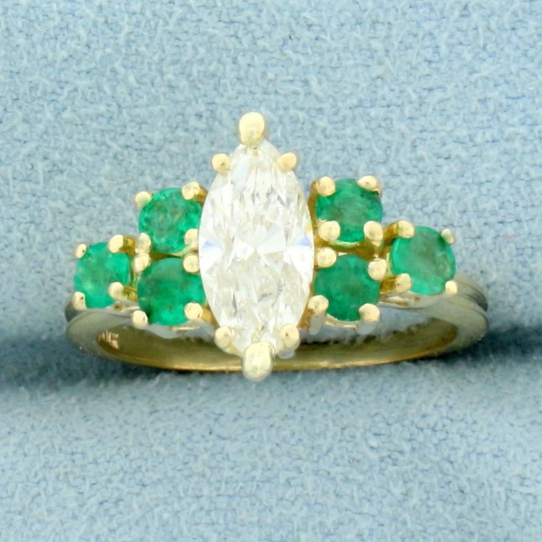 Vintage Marquise Diamond and Emerald Engagement Ring in 14K Yellow Gold: In 14K Yellow Gold. Contains a high quality 10mmx5mm marquise diamond, approximately 1ct, SI clarity/J color. Also contains six high quality natural 3mm Emerald gemstones, .6ct TW, with vibrant green