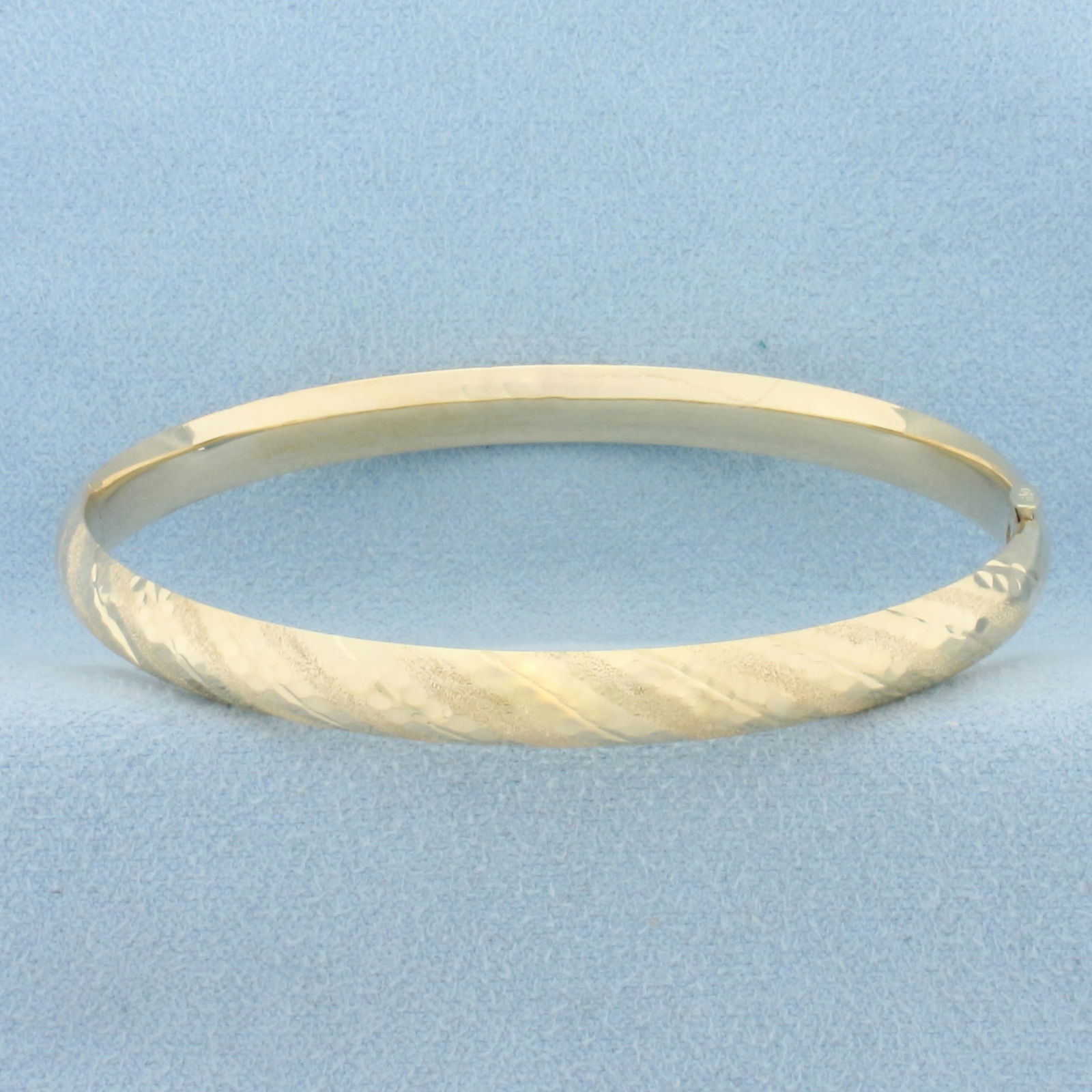 Hinged Textured Striped Bangle Bracelet in 14k Yellow Gold: In 14k Yellow Gold. Interior dimensions: 2 1/2 by 2 1/8 inches. Bar slide locking closure. 5.9g.