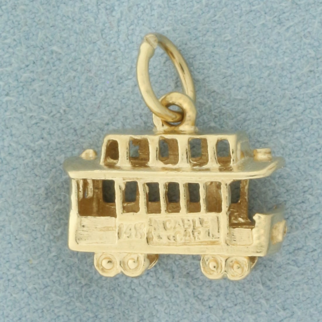 3D San Francisco Cable Car Charm in 14k Yellow Gold: In 14k Yellow Gold. 5/8 inch long (including jump ring). 5/8 inch wide. 3.2g.