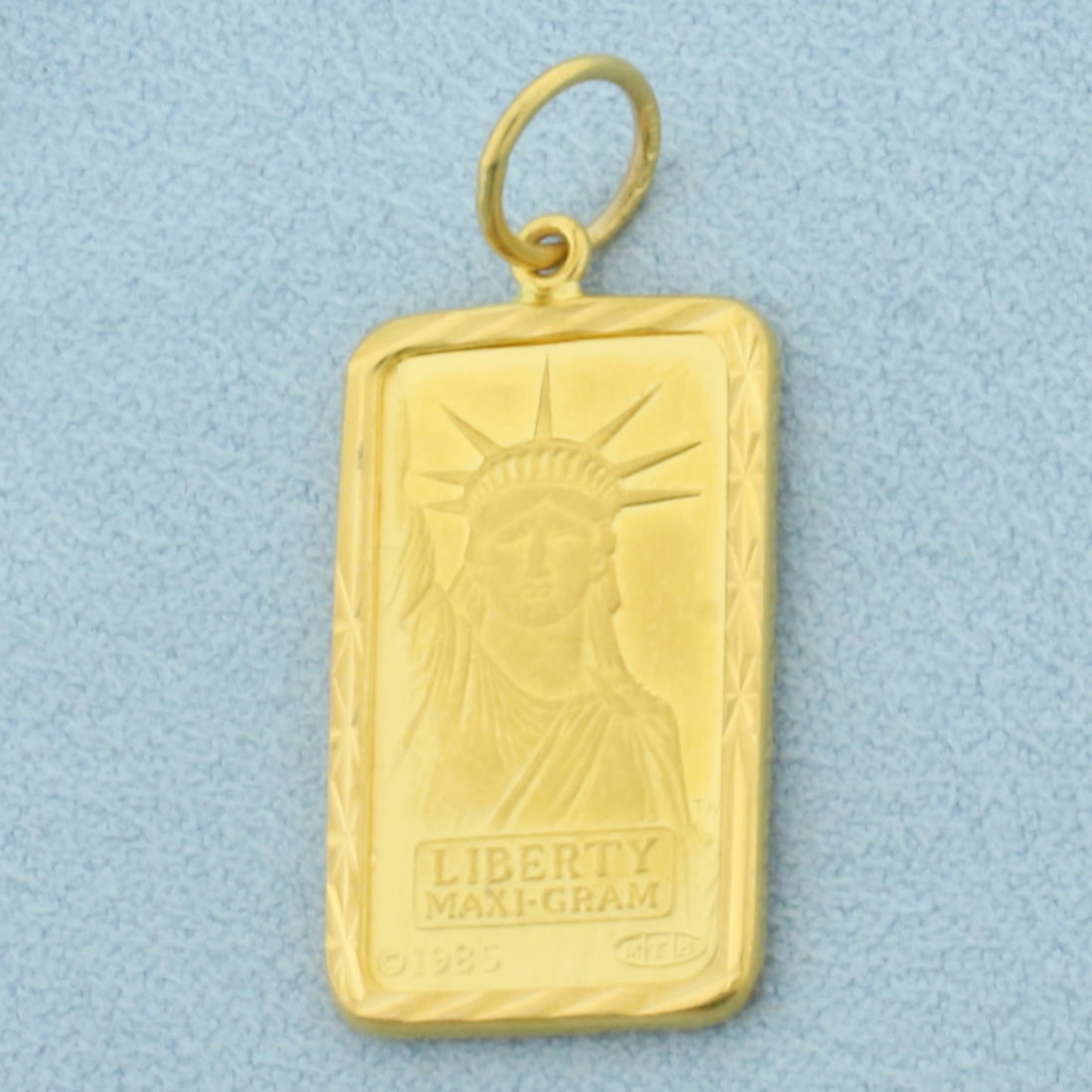 Credit Suisse .999 5g Fine Gold Bar Charm or Pendant in 22k Yellow Gold Bezel: In 22k Yellow Gold Bezel. Contains one Credit Suisse Lady Liberty .999 5g Gold Bar. 1 1/4 inch long (including jump ring). 1/2 inch wide. 6.1g.
