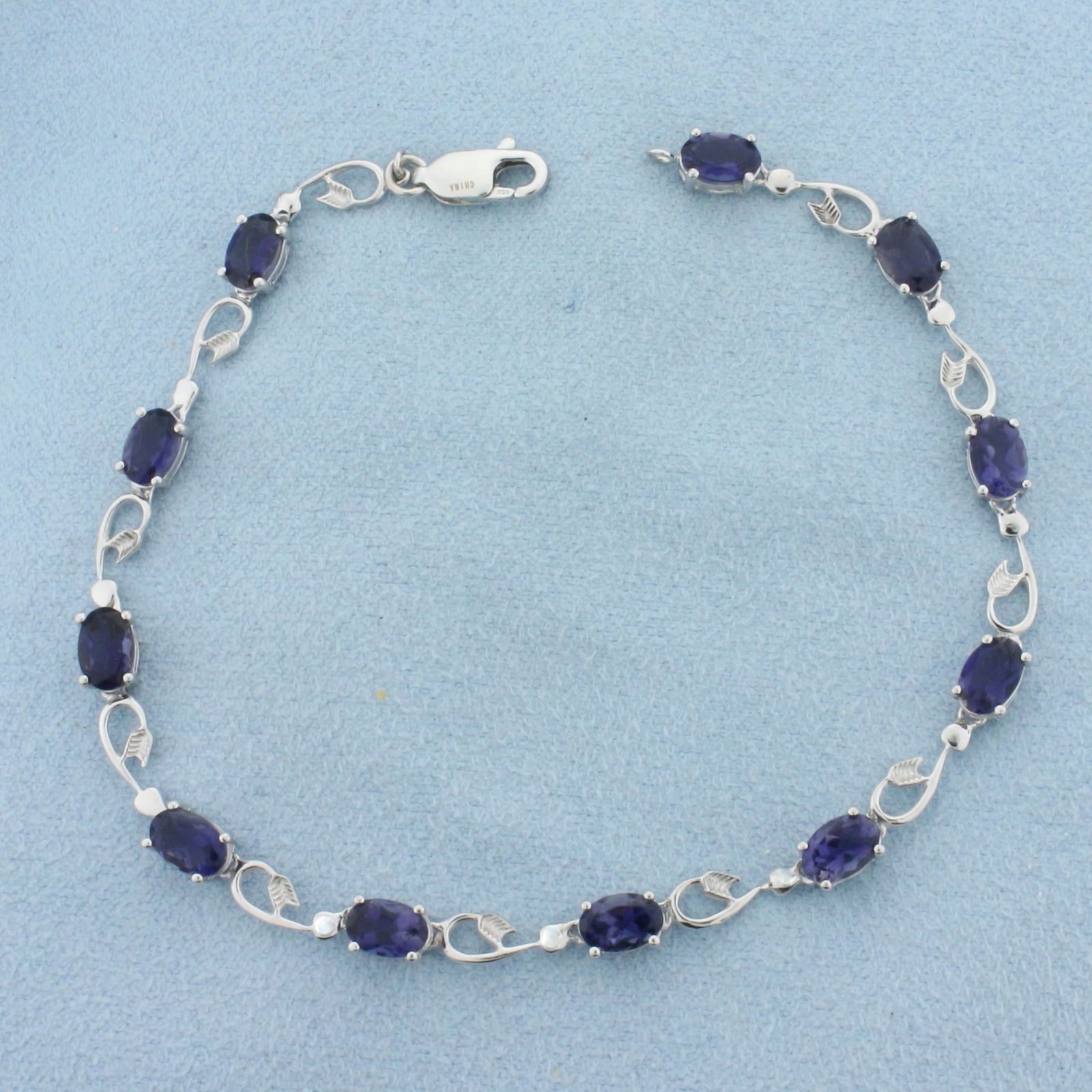 Tanzanite Tennis Bracelet in 10K White Gold: In 10k white gold. Measures 7.5 inches long. Contains eleven 6mm high quality Tanzanite gemstones, approximately 6ct TW, with intense color and excellent clarity. Lobster clasp. 4.7g.