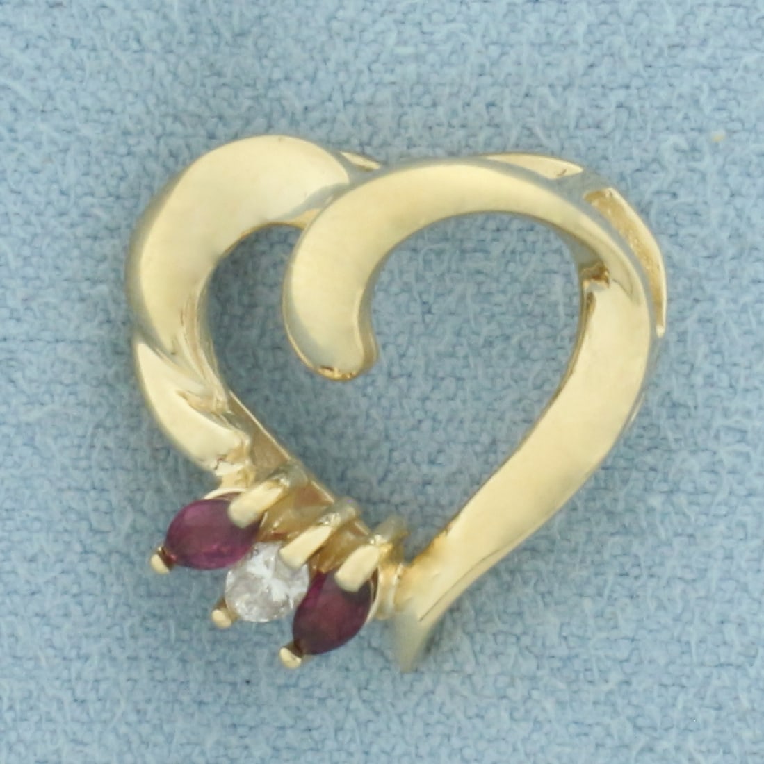 Diamond and Ruby Heart Pendant in 14k Yellow Gold: In 14k Yellow Gold. Contains one 4mm high quality diamond, approximately .1ct, SI clarity/I color . Also contains two 4mm high quality natural Ruby gemstones with intense color and excellent clarity.