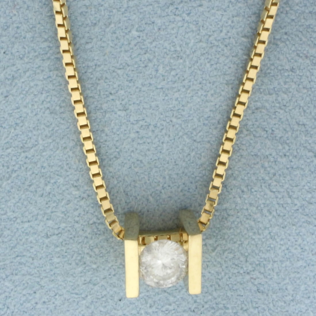 Bar Tension Set Solitaire Diamond Necklace in 14k Yellow Gold: In 14k Yellow Gold. Contains one 1/2ct high quality diamond, H color/I clarity. Pendant is 7mm long. Box link chain is 20 inches long. 1.2mm wide. Lobster clasp. 8.2g.