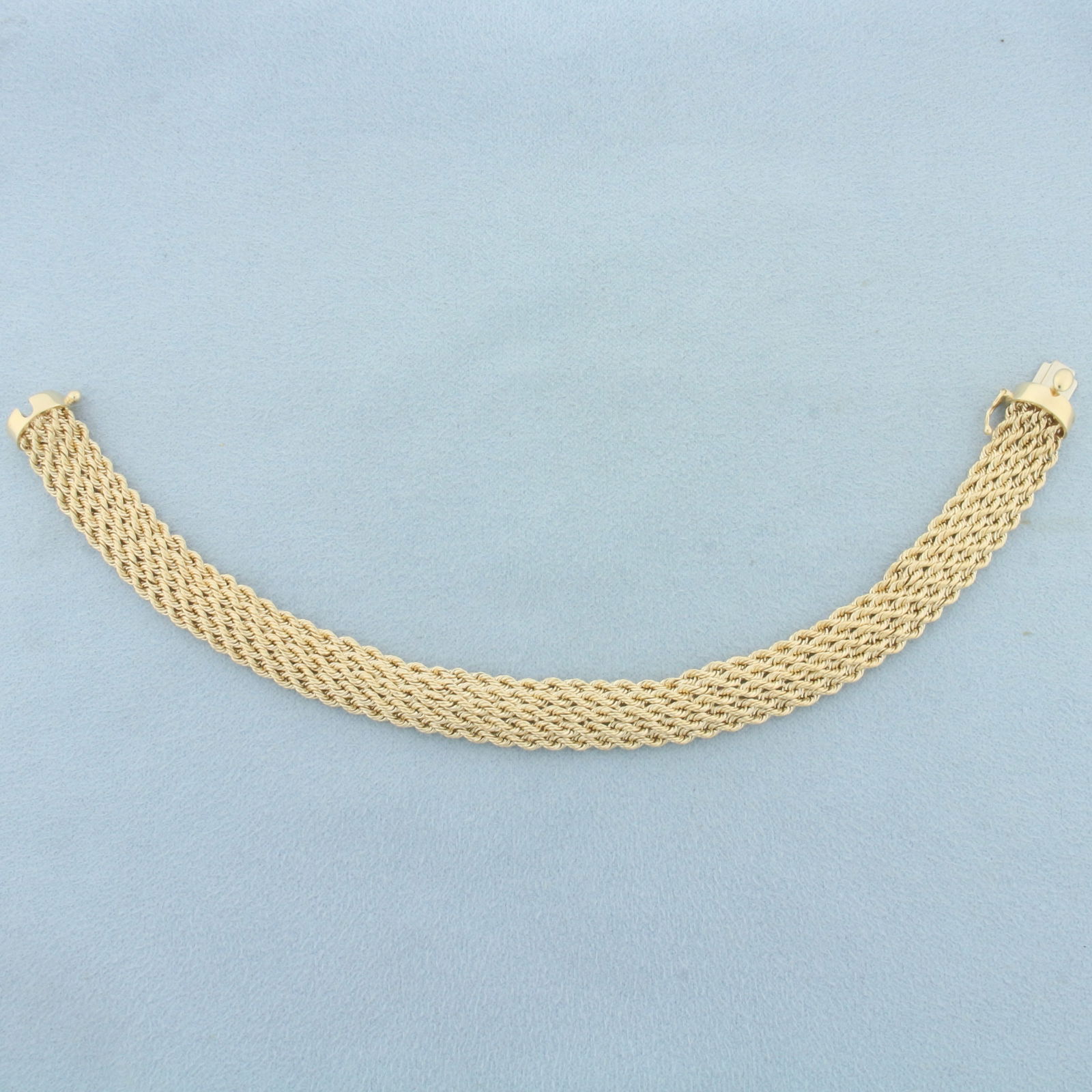 Wide Rope Link Bracelet in 14k Yellow Gold: In 14k yellow gold. 7 5/8 inches long and 3/8 inches wide. Slide clasp with safety latch. 9.4g.