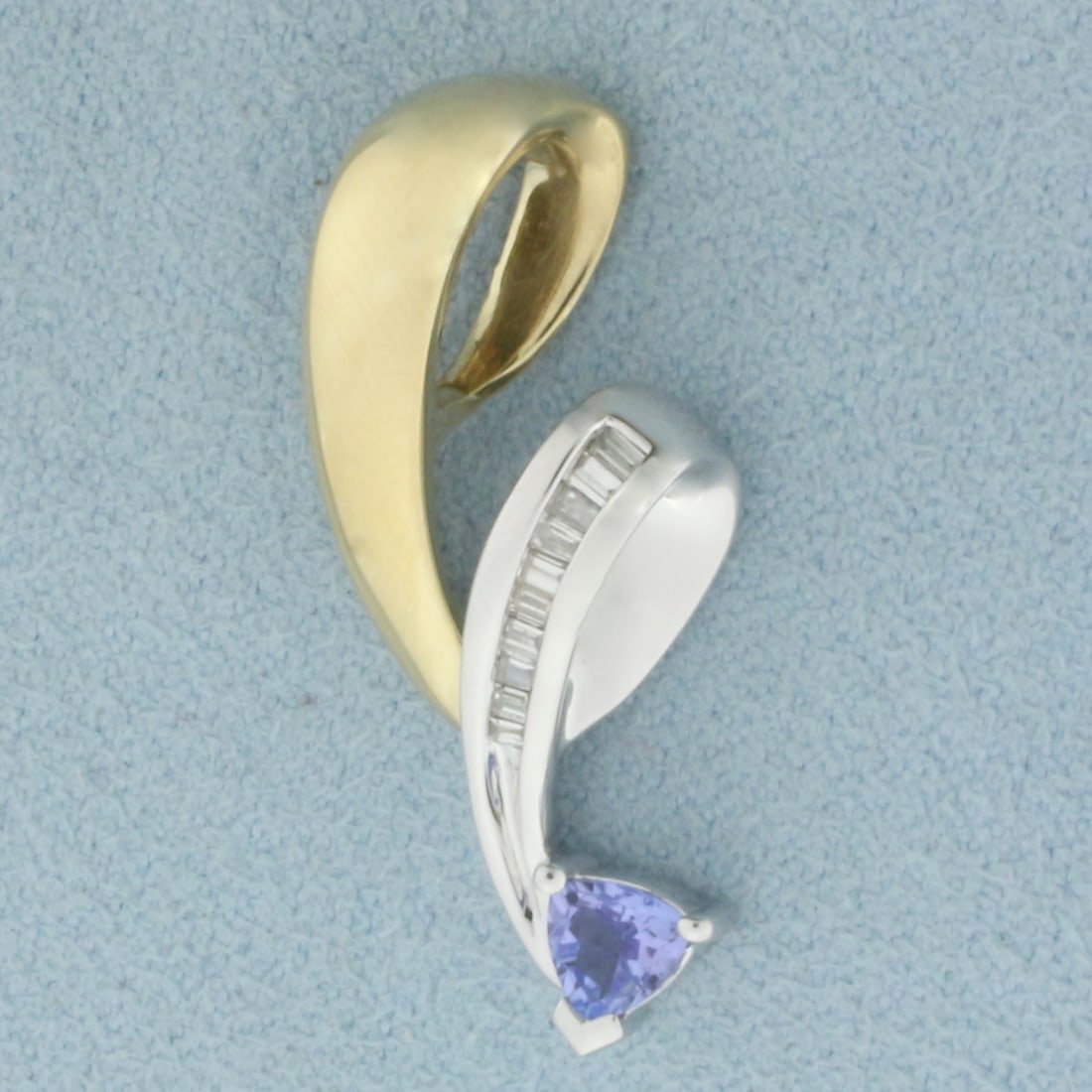 Tanzanite and Diamond Pendant in 10k Yellow and White Gold: In 10k Yellow and White Gold. Contains one 5mm high quality trillion cut natural Tanzanite gemstone, with bright color and excellent clarity. Also contains ten 1.5mm high quality baguette diamonds, SI