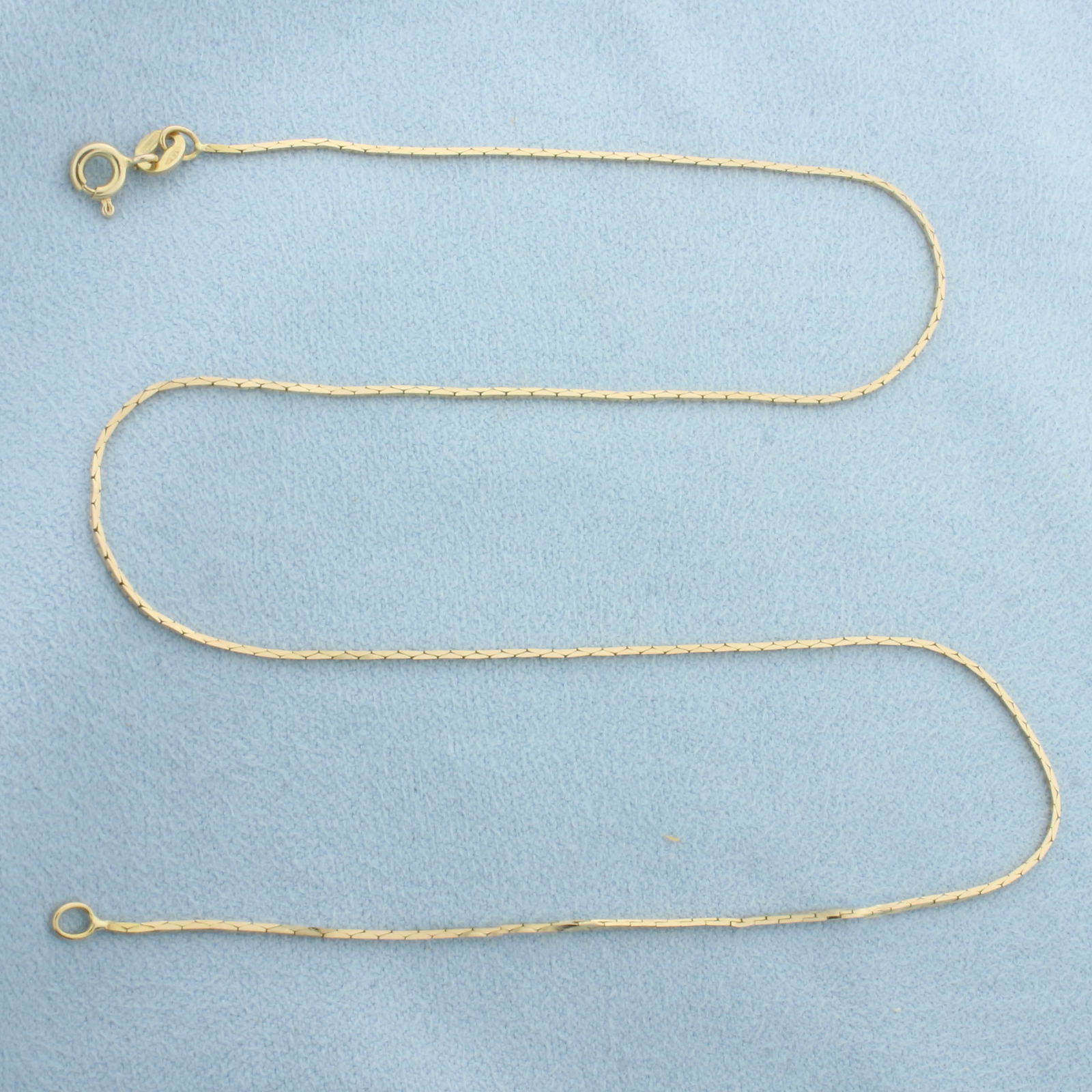 15 Inch Italian Cobra Link Chain Necklace in 14k Yellow Gold: In 14k Yellow Gold. 15 inches long. 0.7mm wide. Made in Italy. Spring clasp. 2.2g.