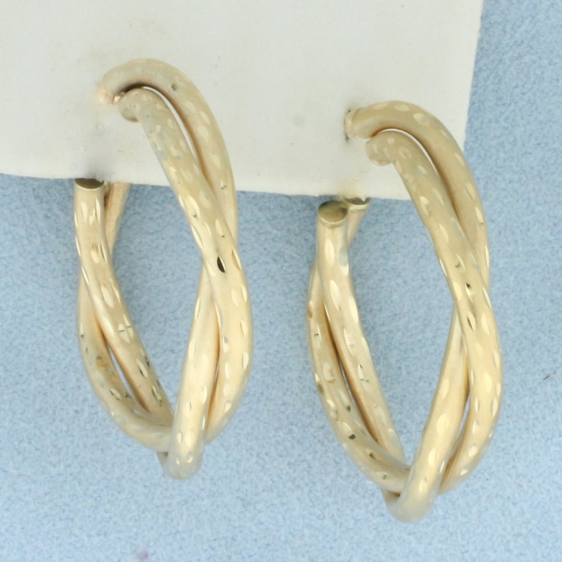 Diamond Cut Satin Finish Twisting Hoop Earrings in 14k Yellow Gold: In 14k yellow gold. 1 1/4 inches long and 1 1/8 inches wide. 4.4g.