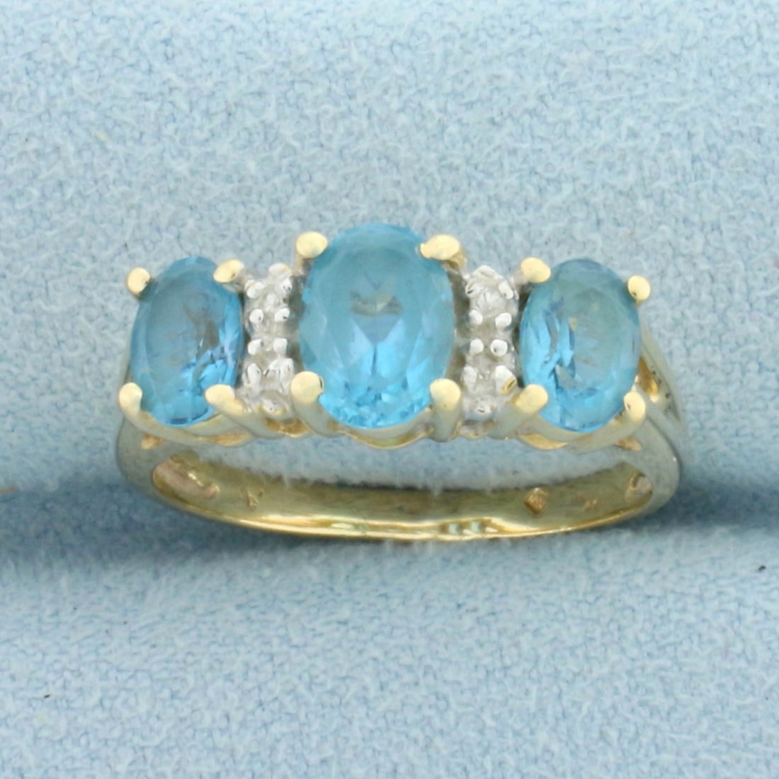 Swiss Blue Topaz and Diamond Ring in 14k Yellow Gold: In 14k Yellow Gold. Contains one 7mm and two 5mm high quality natural Swiss Blue Topaz gemstones, 2ct TW, with electric blue color and excellent clarity. Also contains four high quality 1/2 pt