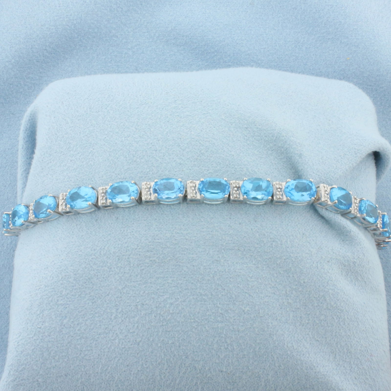 Swiss Blue Topaz and Diamond Tennis Bracelet in 14k White Gold: In 14k White Gold. Contains twenty 5x7mm high quality natural Swiss Blue Topaz gemstones, approximately 20ct TW, with electric blue color and excellent clarity. Also contains forty high quality . 7